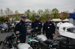 Policjanci  podczas zabezpieczenia zlotu motocyklowego na tle radiowozu