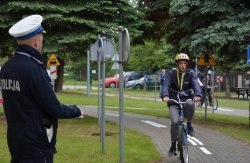 Policjant obserwujący uczestnika konkursu podczas konkurencji jazdy na rowerze