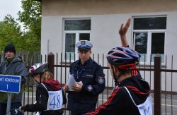 Policjant obserwujący uczestnika konkursu podczas konkurencji jazdy na rowerze